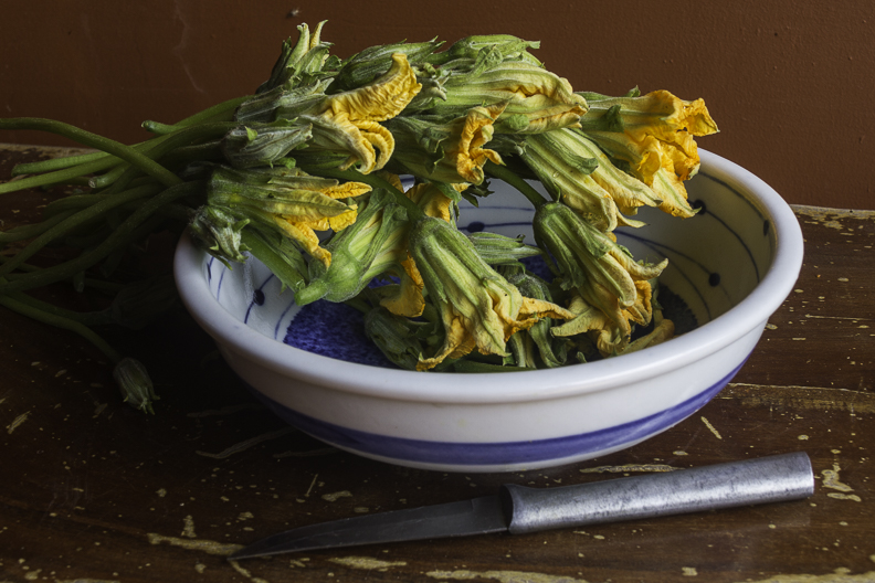 Young leaves and pumpkin flowers being prepared for stir fry.